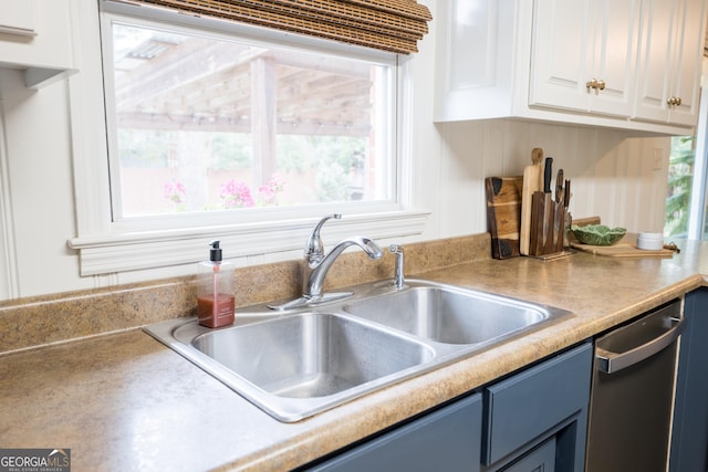 kitchen with a sink, white cabinetry, light countertops, blue cabinetry, and dishwasher