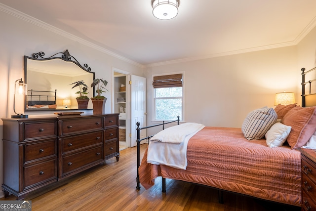 bedroom with light wood-style flooring and crown molding