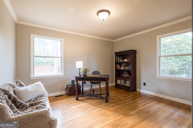 office with ornamental molding, visible vents, light wood-style flooring, and baseboards