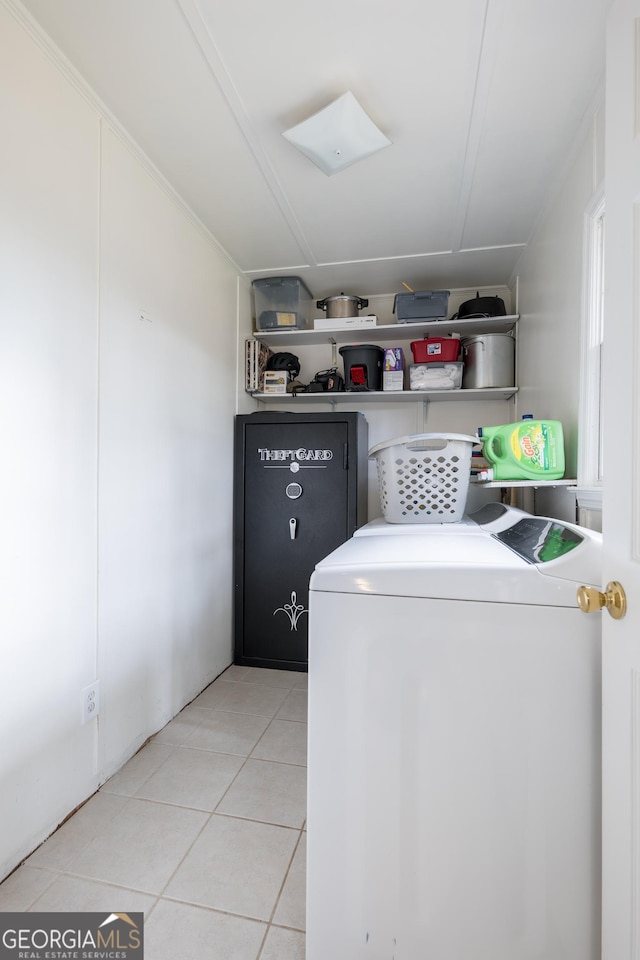 clothes washing area with laundry area, separate washer and dryer, and tile patterned flooring