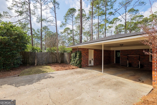 exterior space with driveway, fence, and a carport