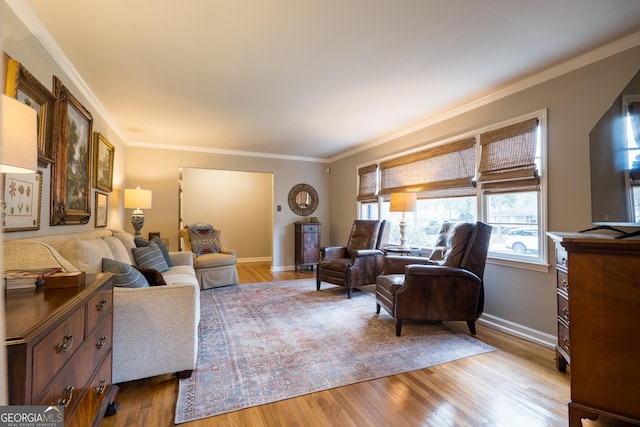 living room featuring light wood finished floors, baseboards, and crown molding