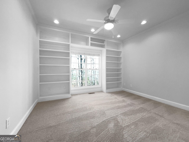 empty room featuring built in shelves, recessed lighting, carpet flooring, and baseboards