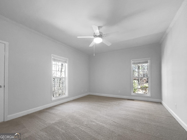 carpeted empty room featuring ceiling fan, ornamental molding, and baseboards