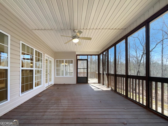 unfurnished sunroom with a ceiling fan and wooden ceiling