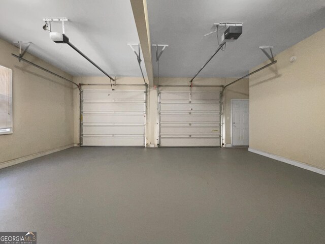 garage with baseboards and a garage door opener