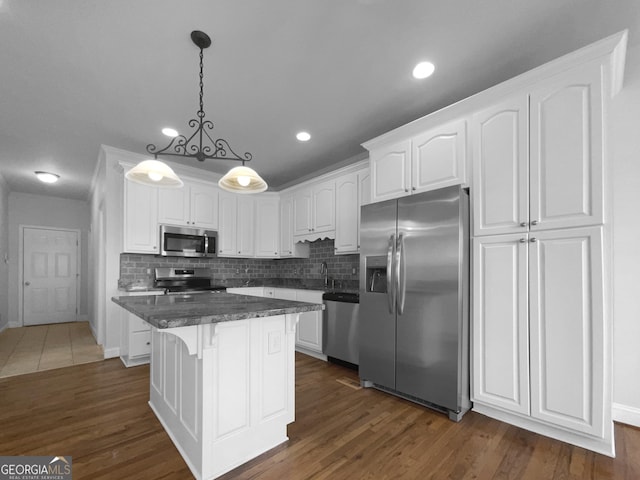 kitchen with stainless steel appliances, dark wood-type flooring, a center island, and white cabinets