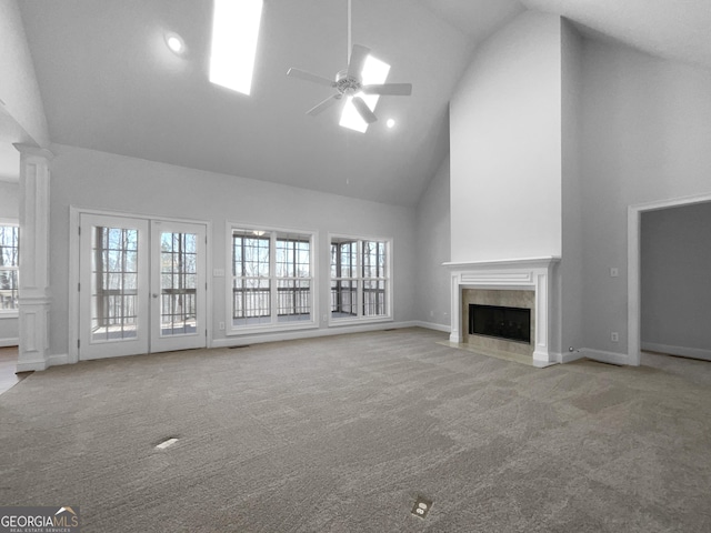 unfurnished living room with carpet, a ceiling fan, a wealth of natural light, and a high end fireplace