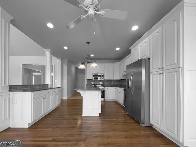 kitchen featuring appliances with stainless steel finishes, a breakfast bar area, decorative backsplash, and white cabinets