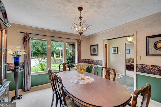 dining room featuring crown molding, a notable chandelier, carpet flooring, a textured ceiling, and baseboards