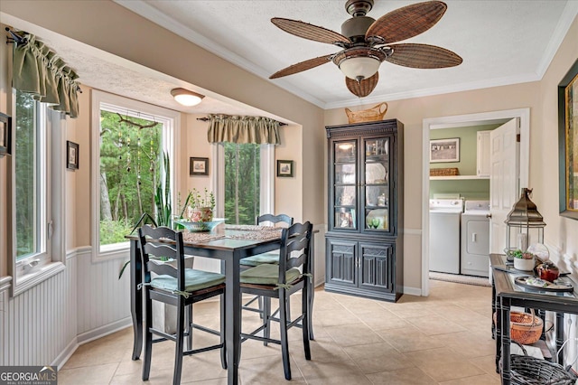 dining room with a wainscoted wall, washing machine and dryer, ornamental molding, and a textured ceiling