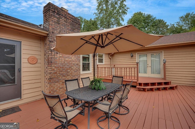 deck featuring outdoor dining space and french doors