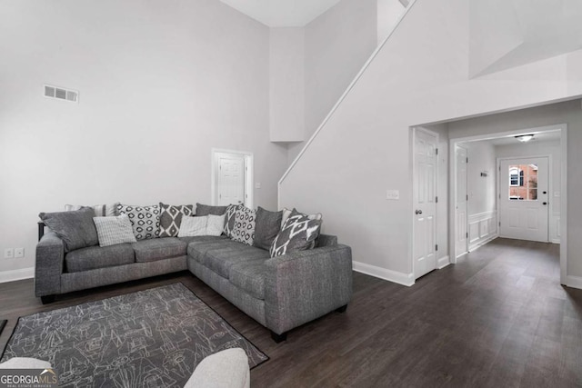 living area with dark wood-style floors, baseboards, and visible vents