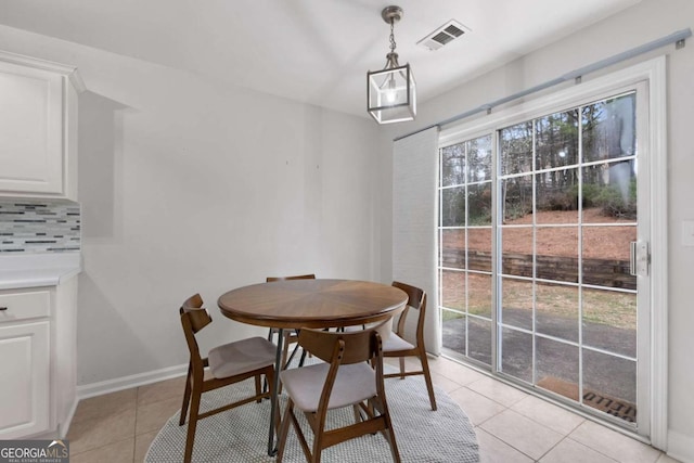 dining room with light tile patterned floors, visible vents, and baseboards