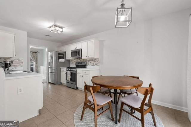 dining area with light tile patterned floors, visible vents, and baseboards