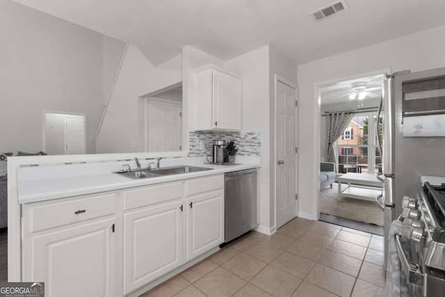 kitchen featuring stainless steel appliances, visible vents, backsplash, a sink, and a peninsula