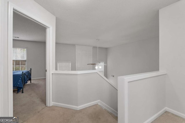 corridor with carpet, an upstairs landing, and baseboards