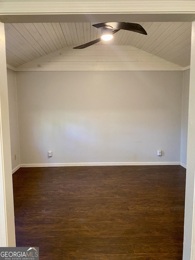 empty room with baseboards, a ceiling fan, vaulted ceiling, and wood finished floors