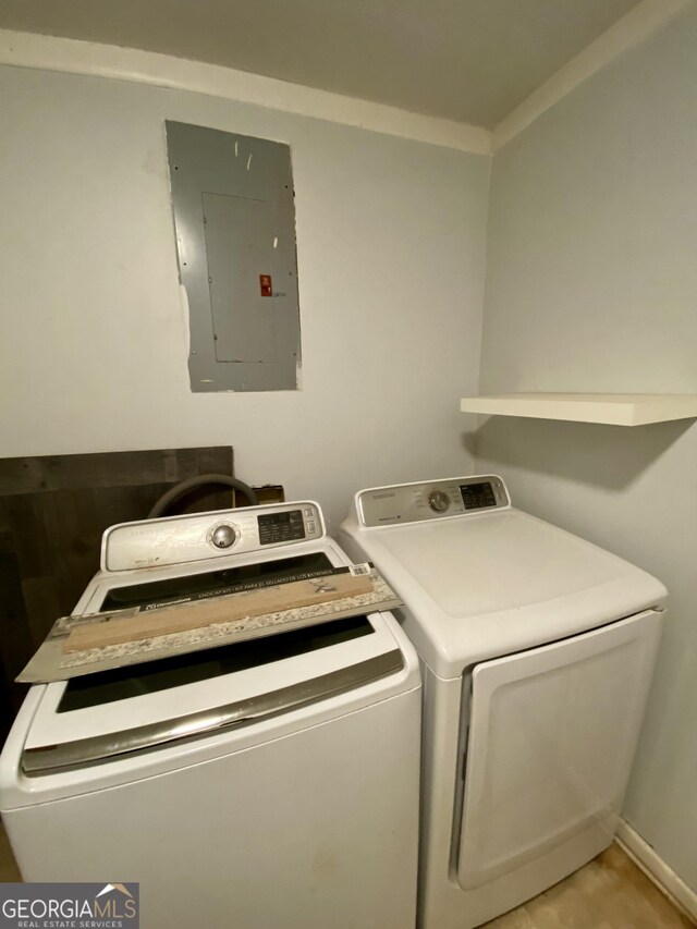 washroom with electric panel, washing machine and dryer, and laundry area