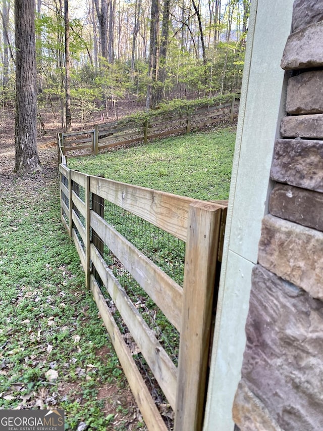 view of gate featuring fence and a yard