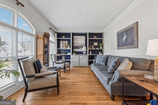 living area featuring built in features, light wood-style flooring, and crown molding