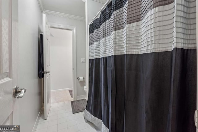 bathroom with baseboards, a shower with shower curtain, toilet, tile patterned floors, and crown molding