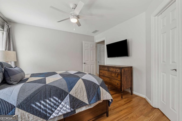 bedroom with light wood-type flooring, a ceiling fan, and baseboards