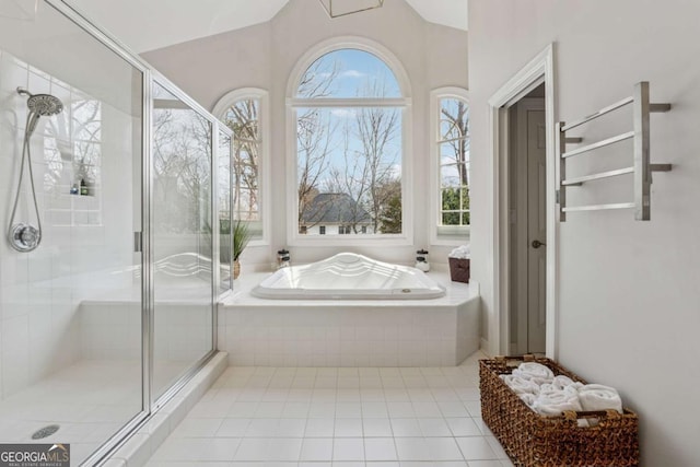 full bathroom featuring a healthy amount of sunlight, a garden tub, a shower stall, and lofted ceiling