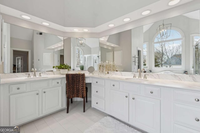 bathroom with lofted ceiling, an inviting chandelier, visible vents, and vanity