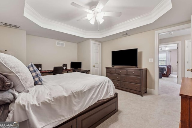 bedroom with light colored carpet, a tray ceiling, visible vents, and ornamental molding