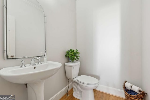 bathroom featuring baseboards, toilet, and wood finished floors