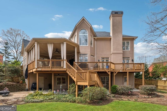 rear view of house with stairs, a patio area, a wooden deck, and stucco siding