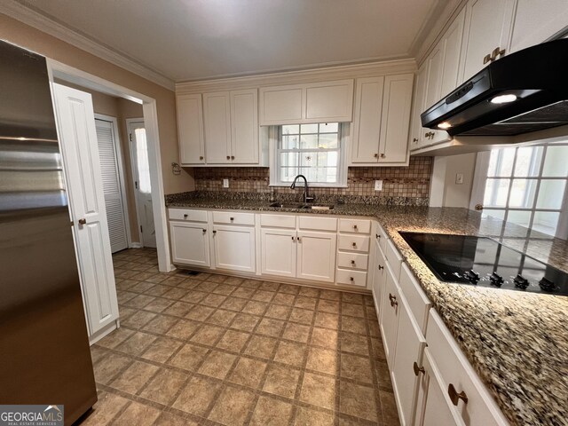 kitchen featuring light floors, white cabinets, a sink, under cabinet range hood, and black appliances