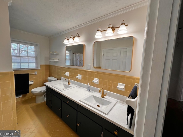 bathroom with a textured ceiling, a sink, toilet, and crown molding
