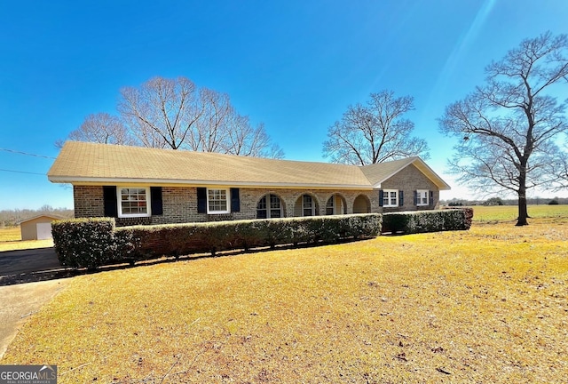 ranch-style home with brick siding and a front lawn