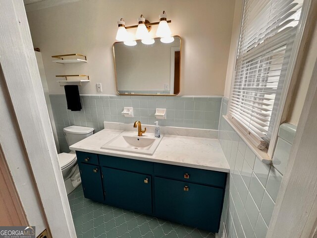 bathroom with toilet, a wainscoted wall, vanity, tile walls, and a shower with curtain