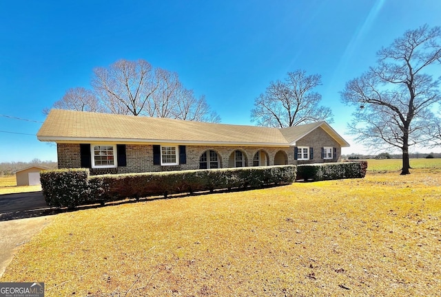 single story home featuring brick siding and a front lawn