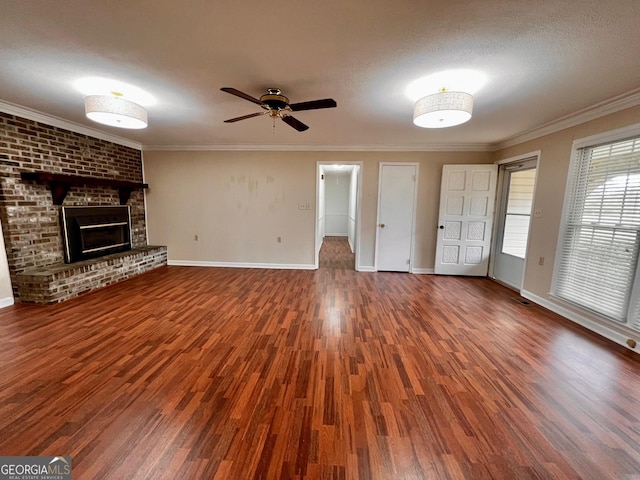 unfurnished living room featuring ornamental molding, a brick fireplace, and wood finished floors