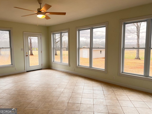 unfurnished sunroom featuring ceiling fan