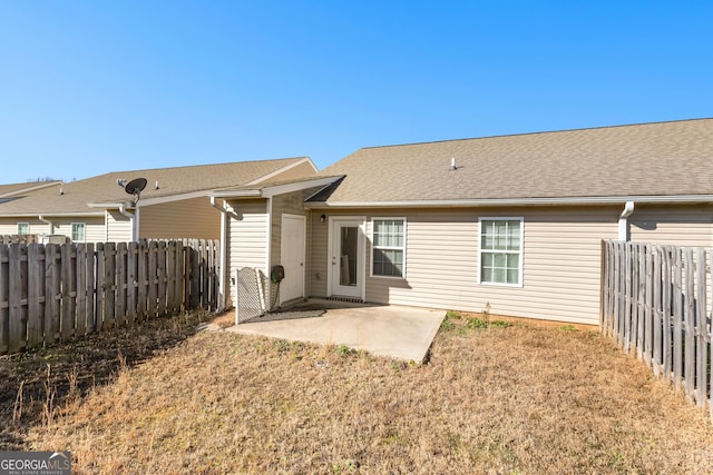 back of house featuring a patio area, fence, and roof with shingles