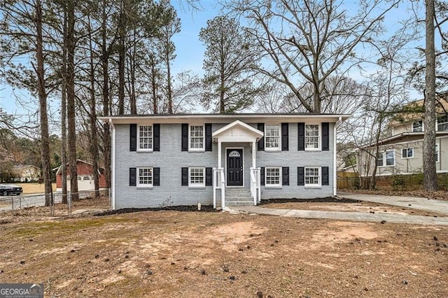 bi-level home with brick siding and fence