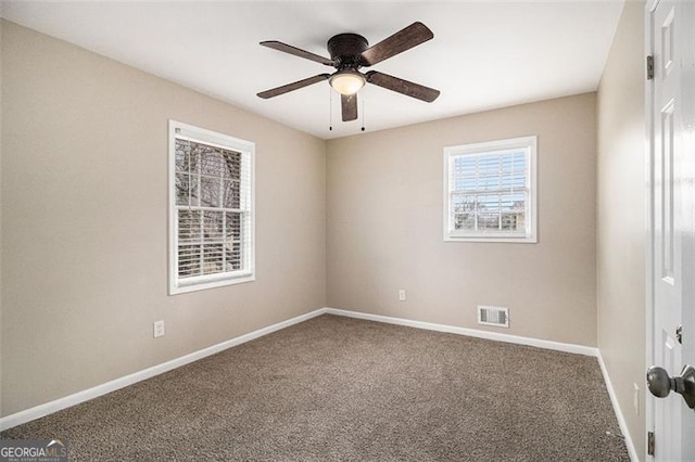 unfurnished room featuring carpet floors, ceiling fan, visible vents, and baseboards