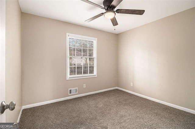 carpeted spare room featuring a ceiling fan, visible vents, and baseboards