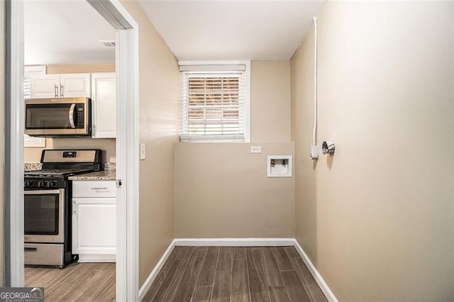 interior space featuring hookup for a washing machine, wood finished floors, and baseboards