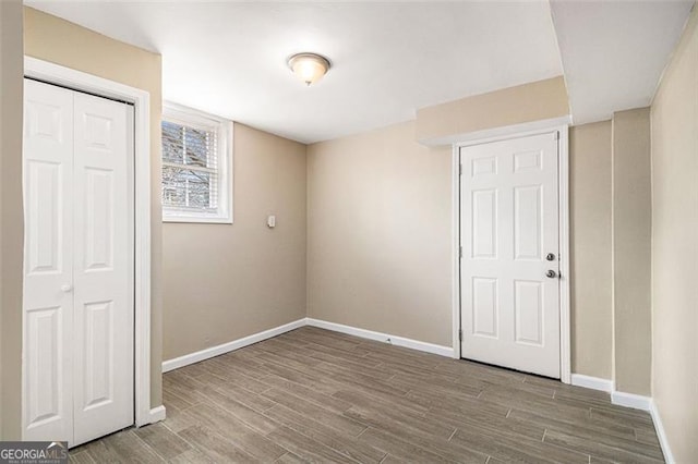 unfurnished bedroom with a closet, baseboards, and wood finished floors