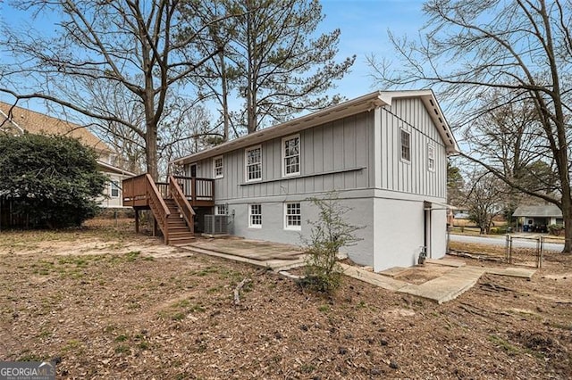 back of property featuring stairs, fence, cooling unit, a wooden deck, and board and batten siding