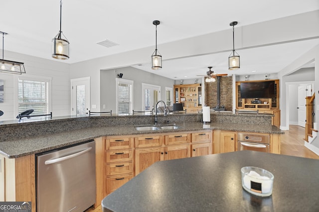 kitchen featuring dishwasher, a sink, visible vents, and decorative light fixtures