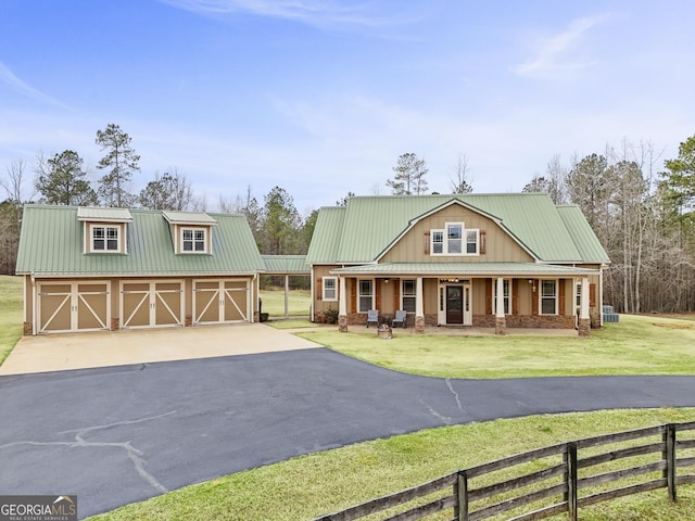 view of front facade with metal roof, a front lawn, a porch, and fence