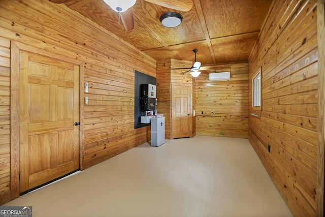 spare room with ceiling fan, wood walls, wooden ceiling, and finished concrete flooring