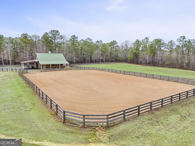 view of home's community with a rural view, an enclosed area, and a wooded view